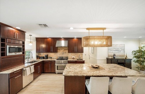 Stuart House | Beautiful 4BR, 3.5BA Stuart retreat with a private screened-in pool. Sleeps 9 and features two en-suite rooms, a modern kitchen, open living, and peaceful canal views perfect for bringing your fishing poles. Minutes to Downtown, dining, and beaches.