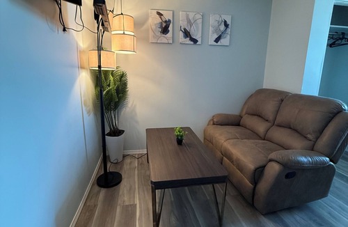 The Pas Apartment | Comfortable Queen Room with a recliner in a Hotel