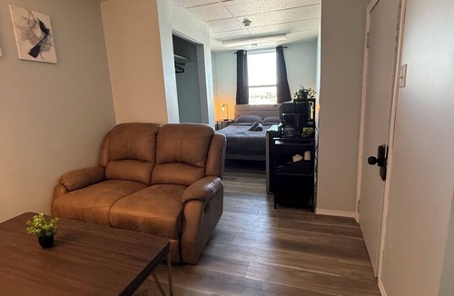The Pas Apartment | Comfortable Queen Room with a recliner in a Hotel