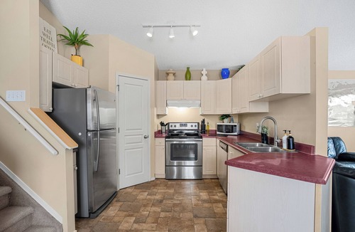 Southeast Edmonton House | Cozy travel-themed retreat near Tamarack shops, dining, games & coffee bar.