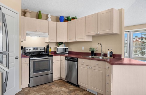 Southeast Edmonton House | Cozy travel-themed retreat near Tamarack shops, dining, games & coffee bar.
