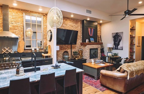 Sheridan Apartment | Luxurious industrial-chic loft in historic downtown Sheridan. This stunning 2-bedroom, 2-bath apartment sleeps up to 9, featuring 2 king suites, 2 1/2 bathrooms sleeping alcove, modern kitchen, fireplace, & Main Street balcony views.
