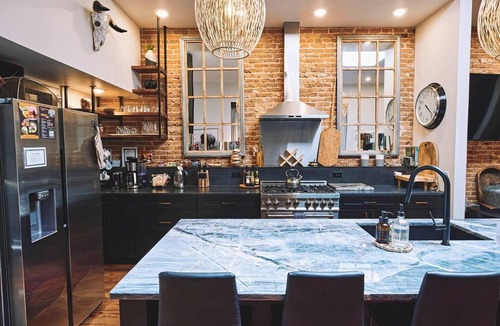 Sheridan Apartment | Luxurious industrial-chic loft in historic downtown Sheridan. This stunning 2-bedroom, 2-bath apartment sleeps up to 9, featuring 2 king suites, 2 1/2 bathrooms sleeping alcove, modern kitchen, fireplace, & Main Street balcony views.
