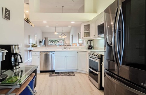 Naples Condo | Relax on the oversized lanai featuring an outdoor kitchen and mid-water view.